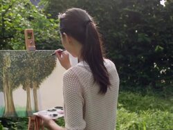 MS Woman painting on an easel outdoors. Stock Footage