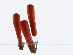 CU TD SLO MO Shot of Carrots, daucus carota, Vegetables Entering Water against White Background / Calvados, Normandy, France Stock Footage