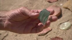 A hand holds an ancient piece of glass in a desert. Stock Footage