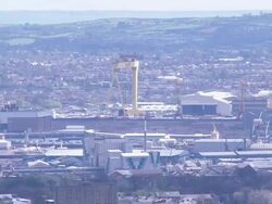 Aeroplane flying into city airport, backed by city, Belfast, Northern Ireland Stock Footage