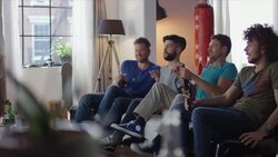 Guys sitting on couch watching horror movie Stock Footage