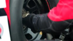 Pit-crewman tightens new race-car tire lug-nuts Stock Footage