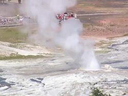 MS ZO AERIAL Shot of tourist watching hot water fountain at Emerald Pool with car parking area and houses / Wyoming, United States Stock Footage