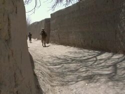 WS ZI Soldiers walking on narrow road / Mausa Qala, Helmand Province, Afghanistan. Stock Footage