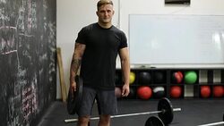 Confident young man holding weight in gym Stock Footage