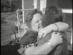 A woman runs out of her house and excitedly greets Jewish refugees as they get out of a car. News Clip