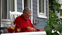 A retiree reads the newspaper on his front porch. Stock Footage