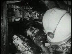 Astronaut John Glenn removes his protective boots before entering the Friendship 7 space capsule. News Clip