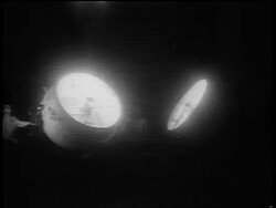B/W 1951 two large klieg lights pointing at sky + rotating at night Stock Footage