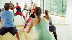 Exercise class doing squats in gym studio Stock Footage