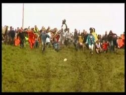 Cheese Rolling: crowd watching and participants chasing cheese down hill, Caerphilly, UK. 2007; short sequence. Stock Footage