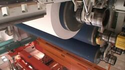 Several cylinders of a machine spin as a tray moves underneath it in a paper mill. Stock Footage