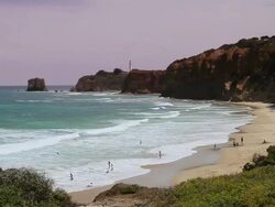 WS View of Bathers playing in surf and on beach near Aireys Inlet lighthouse / Aireys Inlet, Victoria, Australia Stock Footage