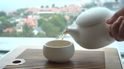 hand pouring tea beside window Stock Footage