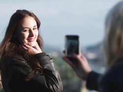 woman taking a photo of another woman with her cell phone camera Stock Footage