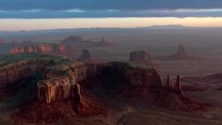 Red hills, mesas, buttes, and rock formations rise above the desert in Arizona's Monument Valley Navajo Tribal Park. Stock Footage