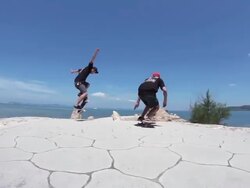 MS POV Two men's skateboarding on side walk near beach area, showing stunts / Uruma, Okinawa, Japan Stock Footage