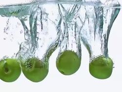 CU TD SLO MO Shot of Granny Smith Apples, malus domestica, Fruits entering Water against White Background / Calvados, Normandy, France Stock Footage