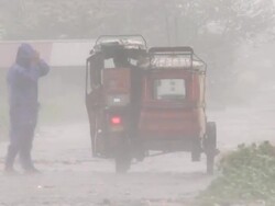 Man and child struggle with motorbike taxi in strong wind and rain from Super Typhoon Megi or Juan, NE Luzon, Philippines Oct 2010 / AUDIO Stock Footage