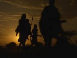 Maasai or Samburu Warriors singing and dancing, silhouetted in sunset, WITH AUDIO Stock Footage