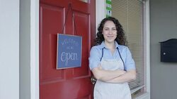 Young business woman opening a small business with a 'We Are Open' sign Stock Footage