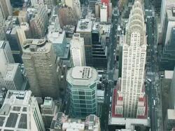 Aerial view looking  down at midtown Manhattan as helicopter flies right over Chrysler building NYC Stock Footage