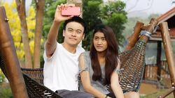 Smiling couple taking selfie on their phone in a park Stock Footage