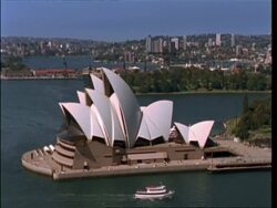 MS low angle, boat passing left to right under Sydney Harbour Bridge, high-rise buildings on skyline, Australia Stock Footage