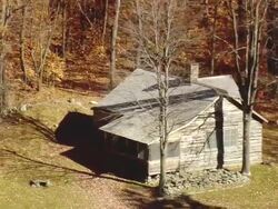 MS AERIAL DS View of Robert Frost Cabin surrounded by trees at Homer Noble Farm / Vermont, United States Stock Footage
