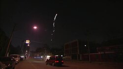 A firework shoots sparks into the sky on a street in Beijing. Stock Footage