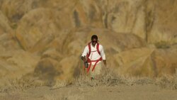 A young man backpacking in a mountainous desert. Stock Footage