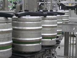 MS Shot of Aluminum beer barrels moving on conveyor at beer production at brewery, Bitburger Pils Stock Footage