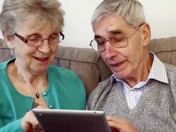 Senior couple in 70s using a digital tablet at home. Stock Footage