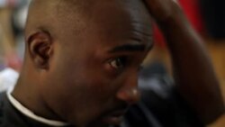 Customer rubs his head and inspects himself in the mirror after a haircut at a New York City barbershop Stock Footage