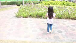 Cute girl is watching flowers in amusement park Stock Footage