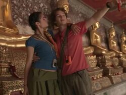 MS SHAKY Young couple photographing self in front of golden Buddha statue at Wat Phra Kaew (Temple of the Emerald Buddha), Bangkok, Thailand Stock Footage
