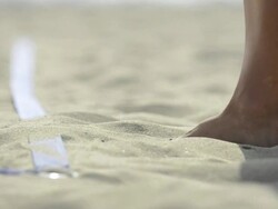 ECU of female beach volleyball players foot as she wipes sand off the line. Stock Footage