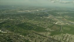 Buildings and fields populate the edges of a river. Stock Footage