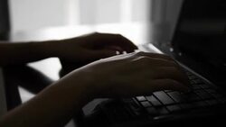 Silhouette of female hands typing on a laptop Stock Footage
