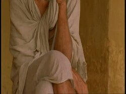 MS tilt up to Hindu priest drinking outside Temple, India Stock Footage