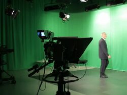Mature male TV presenter walking into Television studio Stock Footage