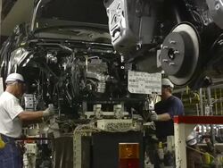MS Two Workers align and installing  engine in minivan chassis at an auto assembly plant / Princeton, Indiana, United States Stock Footage
