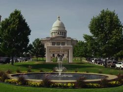 Drive by wide shot of Arkansas State Capitol building with water fountain in foreground Stock Footage