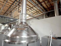 DS stainless steel boil kettle in modern micro brewery next to whirl pool tank / Thousand Palms, California, USA Stock Footage