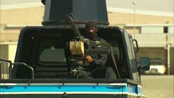 A soldier sits behind a machine gun in the back of an armored vehicle. Stock Footage