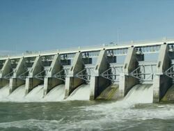 WIde shot of Water spillway behind electricity generating dam Stock Footage