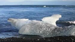 Melting ice on the beach by the Jokulsarlon ice lagoon, one of the most visited places in Iceland. It has been created by the rapid retreat of the Breidamerkurjokull glacier which sweeps down off the Vatnajokull ice cap. Ice bergs calve off the front and f Stock Footage