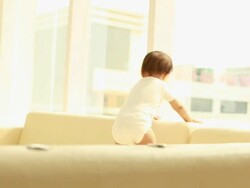 Baby boy walking on sofa  Stock Footage
