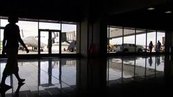 A traveler's image reflects on the shiny floor of an airport concourse. Stock Footage