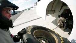 Pit-crewman replaces race-car tire Stock Footage
